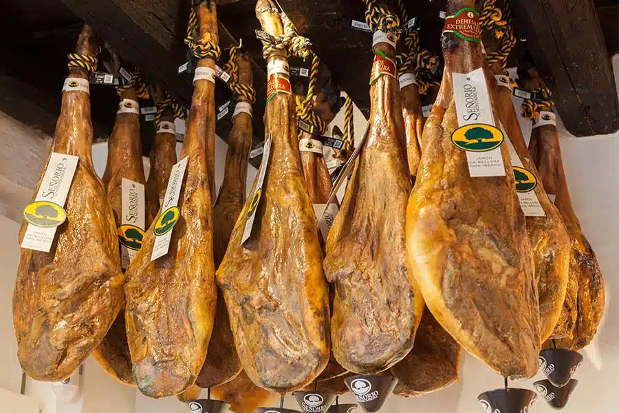 Jambon ibérique de bellota avec sceau de couleur suspendu en cave de maturation