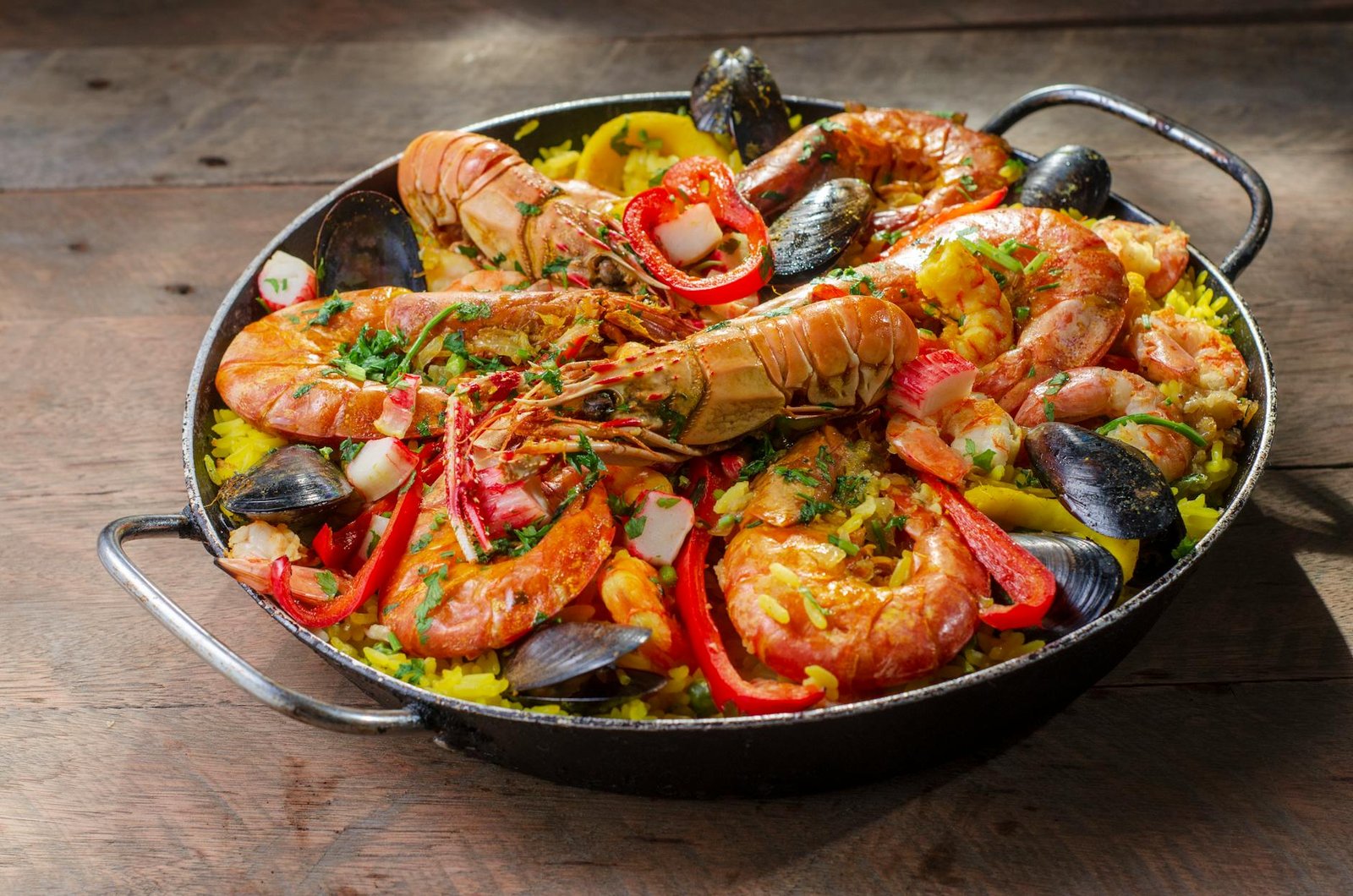 Plat traditionnel de riz valencien dans sa poêle sur fond rustique