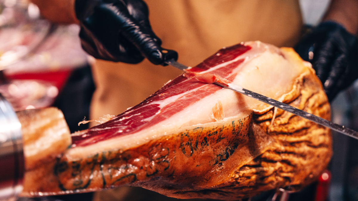 Découpe artisanale de jambon ibérique en tranches fines pour apéritif