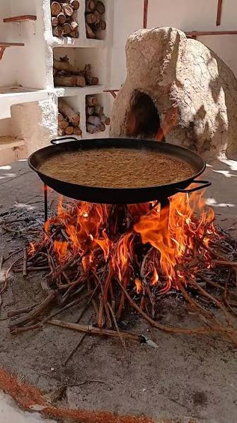 Cocinar a la brasa con leña de olivo durante una competición gastronómica.