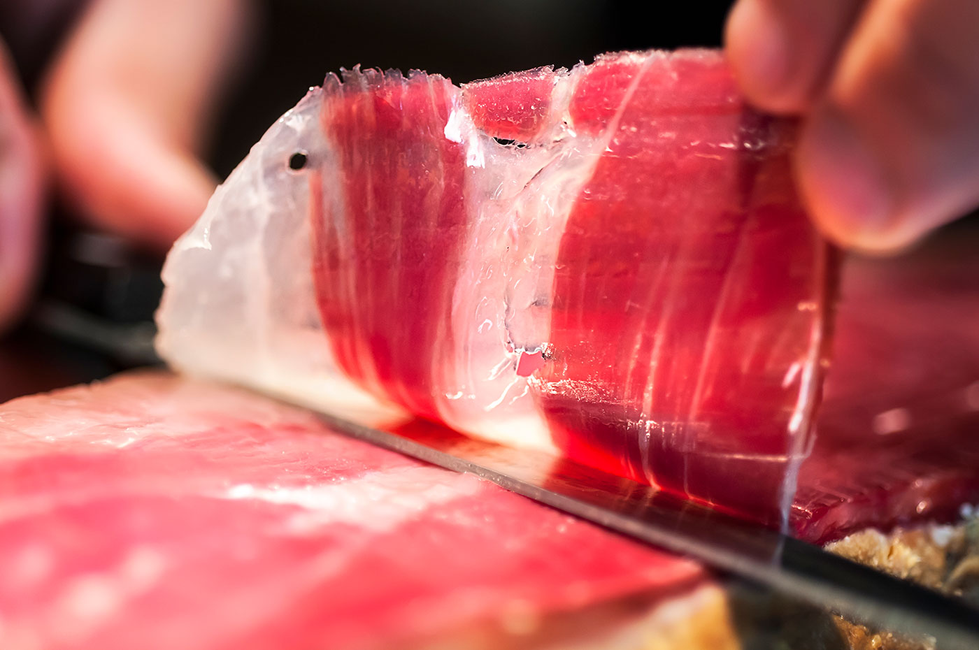 Découpage traditionnel d'un jambon espagnol sur son support en bois