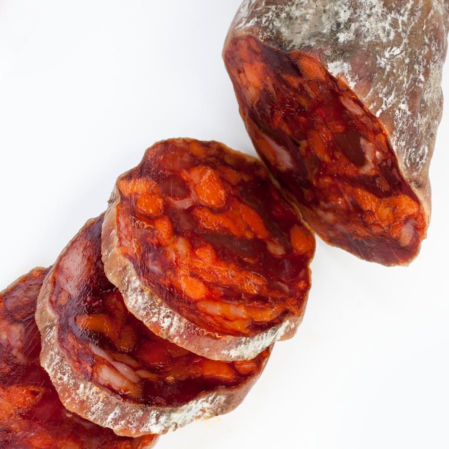 Produits locaux espagnols exposés sur étal de marché traditionnel avec jambon ibérique