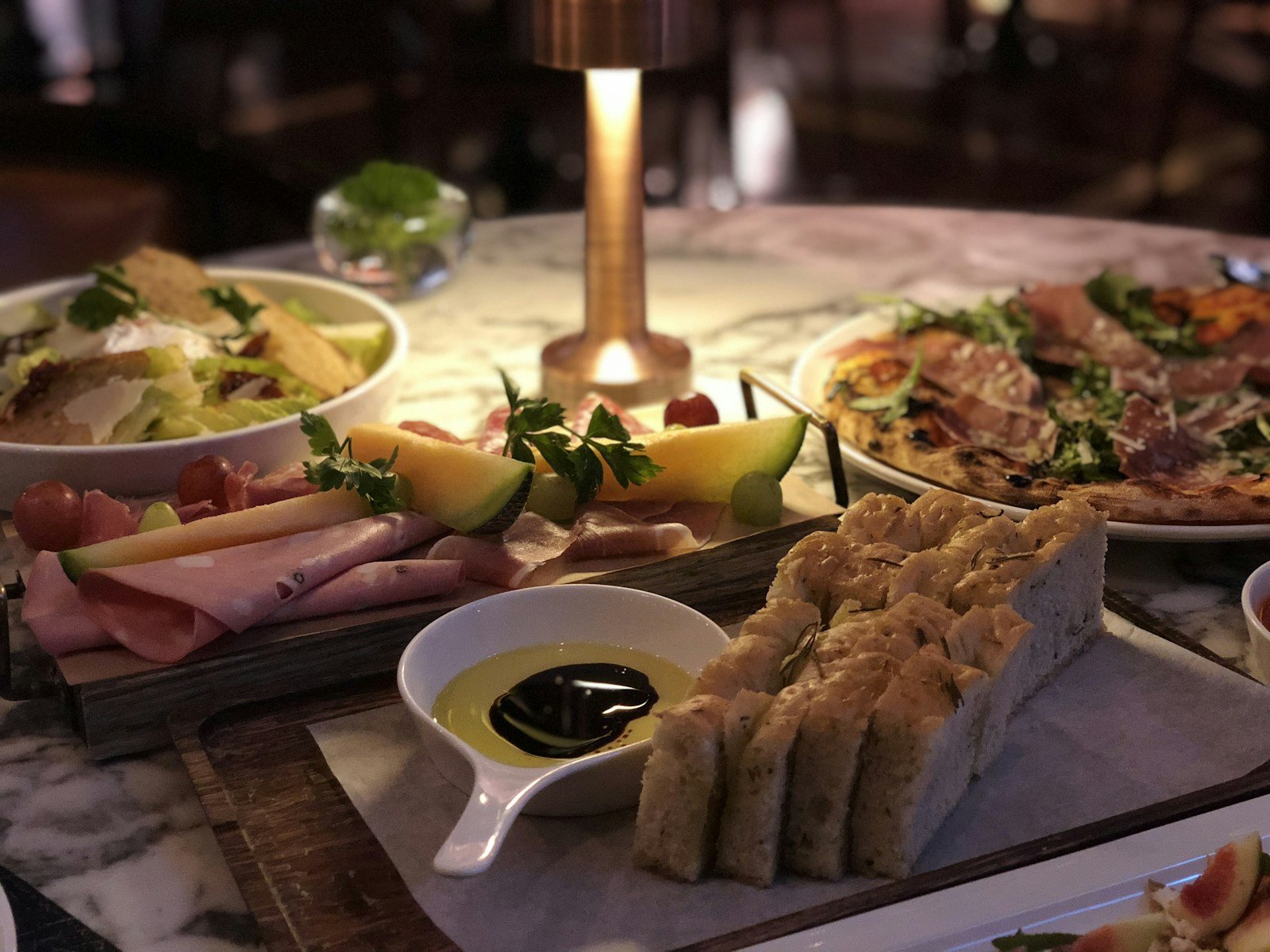 Éclairage chaud latéral sur une planche de charcuterie lors d'une réception