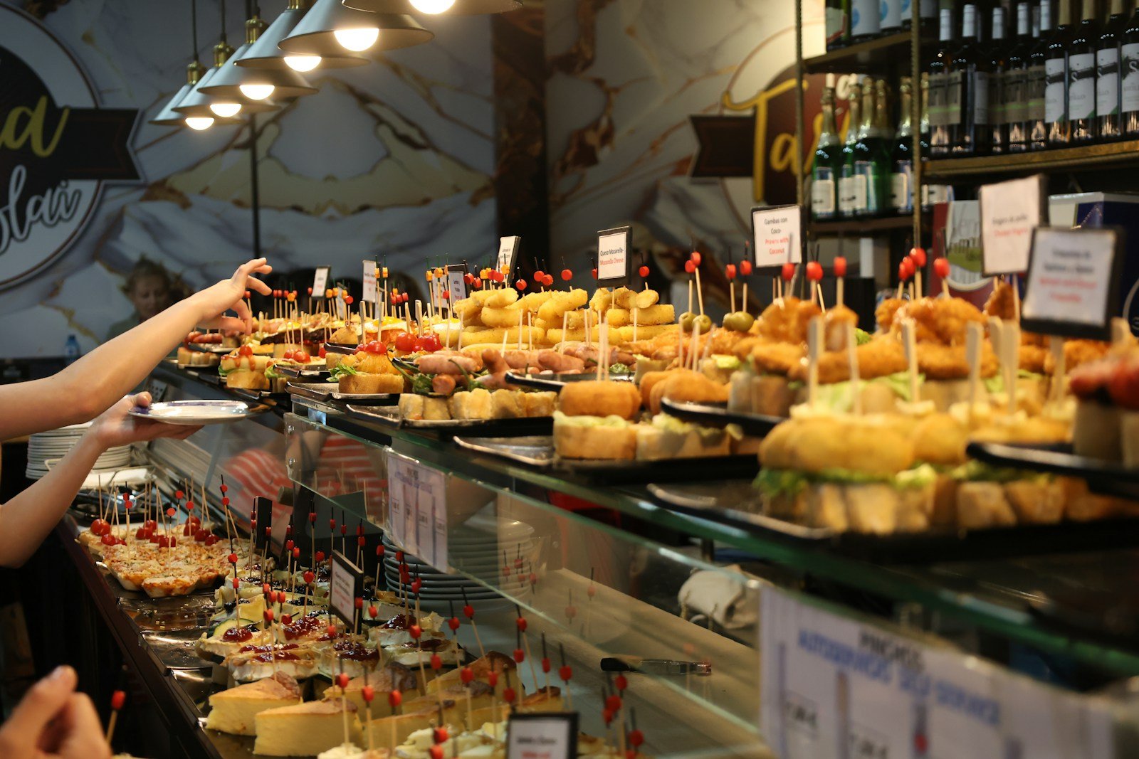 Plateaux de bouchées espagnoles sur pain disposés sur un comptoir en bois