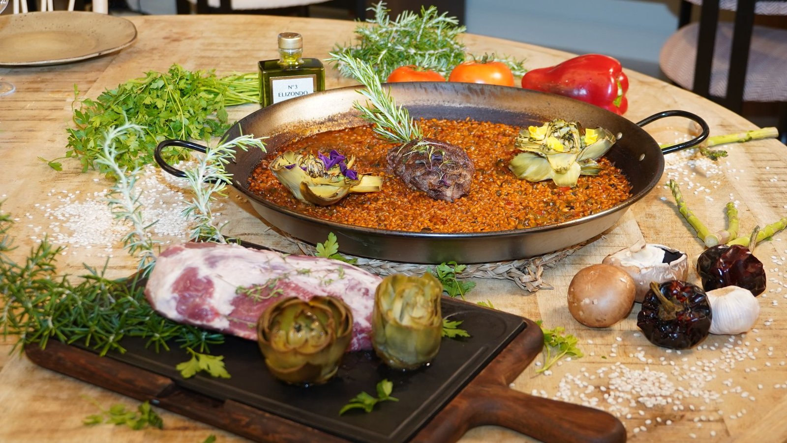 Produits crus disposés sur un plan de travail : lapin, poulet, haricots plats, safran et riz rond