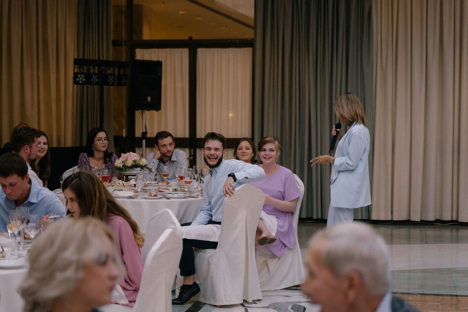Invités partageant un repas autour d'une longue table lors d'un mariage en soirée
